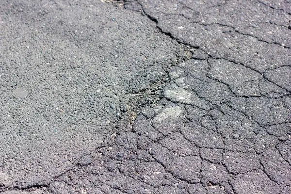 ひび割れが入ったアスファルト路面